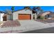 Quaint single-story home featuring a red garage door, a covered front porch, and low-maintenance landscaping at 4768 W Montara Cir, Las Vegas, NV 89121