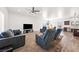 Spacious living room with wood-look floors, ceiling fan, and an open-concept layout at 50 White Burch Ln, Pahrump, NV 89048