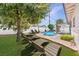 Inviting backyard with a sparkling pool, lounge chairs, and lush greenery, perfect for relaxation and entertaining at 5168 Wilbur St, Las Vegas, NV 89119