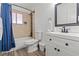Bright bathroom features a tub and shower combination with a white vanity and sink at 5168 Wilbur St, Las Vegas, NV 89119