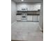 Bright kitchen features white cabinetry, tile flooring, modern appliances, and granite countertops at 5241 River Glen Dr # 184, Las Vegas, NV 89103