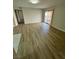 Open living space featuring durable laminate flooring and sliding glass door access to a balcony at 5241 River Glen Dr # 184, Las Vegas, NV 89103