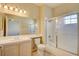 Bathroom features a shower-tub combo with glass doors, single sink vanity and tile flooring at 5250 S Rainbow Blvd # 2120, Las Vegas, NV 89118
