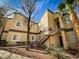 Tan two-story condo with staircase, mature trees, and manicured landscaping at 5250 S Rainbow Blvd # 2120, Las Vegas, NV 89118