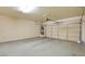 Clean and well-lit garage space featuring a painted floor, water heater, and an automatic garage door at 5250 S Rainbow Blvd # 2120, Las Vegas, NV 89118