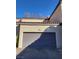 Exterior shot of a well-maintained attached garage with a gray door and desert landscaping at 5250 S Rainbow Blvd # 2120, Las Vegas, NV 89118