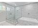 Bathroom with a glass enclosed shower with a tub and decorative tile at 5525 Campbell Rd, Las Vegas, NV 89149