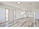 Inviting living room with updated wood grain flooring, white walls and trim, and an eat in kitchen at 603 W Adams Ave, Las Vegas, NV 89106