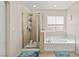 Bright bathroom featuring a glass-enclosed shower and soaking tub with tile surround at 7017 Pink Flamingos Pl, North Las Vegas, NV 89084