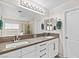Bright bathroom featuring a double sink vanity, modern fixtures, and a glass-enclosed shower for convenience at 7017 Pink Flamingos Pl, North Las Vegas, NV 89084