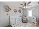 Charming Bedroom featuring a crib, decorative accents, and a ceiling fan, creating a comforting space at 7017 Pink Flamingos Pl, North Las Vegas, NV 89084