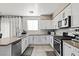 Modern kitchen featuring stainless steel appliances, white cabinets, and tile backsplash, ready for culinary adventures at 7017 Pink Flamingos Pl, North Las Vegas, NV 89084