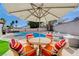 Backyard patio area with pool, outdoor seating under a large shade umbrella at 7285 Pinebrook Cir, Las Vegas, NV 89147