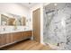 Bathroom with marble countertops, dual sinks, and a glass-enclosed shower with gold fixtures at 74 Innisbrook Ave, Las Vegas, NV 89113