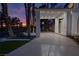 Grand driveway with palm trees, highlighted by soft lighting and providing a luxurious entrance at 74 Innisbrook Ave, Las Vegas, NV 89113