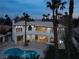 Elegant two-story home featuring a private pool, balcony and stucco siding and mature palm trees at 74 Innisbrook Ave, Las Vegas, NV 89113