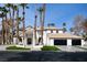 Stately two-story home featuring a tile roof, a three-car garage, and lush landscaping with swaying palm trees at 74 Innisbrook Ave, Las Vegas, NV 89113