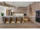 Modern kitchen featuring wooden cabinets, a marble island with seating, and stainless steel appliances, perfect for culinary enthusiasts at 74 Innisbrook Ave, Las Vegas, NV 89113