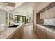 Open kitchen featuring a marble waterfall island, modern faucet, backyard views, and light wood cabinets at 74 Innisbrook Ave, Las Vegas, NV 89113