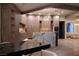 Bright kitchen features waterfall island with marble countertops, bar seating, and custom light wood cabinets at 74 Innisbrook Ave, Las Vegas, NV 89113