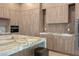 Modern kitchen featuring wood cabinets, marble countertops and backsplash, a large island, and built-in appliances at 74 Innisbrook Ave, Las Vegas, NV 89113