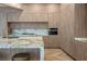 Modern kitchen featuring light wood cabinetry, marble countertops, built-in coffee maker, and chevron floors at 74 Innisbrook Ave, Las Vegas, NV 89113