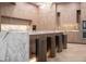 Kitchen island featuring waterfall marble countertops, modern stools, and stylish light wood cabinetry at 74 Innisbrook Ave, Las Vegas, NV 89113