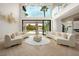 Bright living room with modern sofas, herringbone floors, and large windows providing scenic outdoor and pool views at 74 Innisbrook Ave, Las Vegas, NV 89113