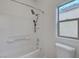 Bright bathroom featuring a shower and toilet, next to a window at 7873 Marbledoe St, Las Vegas, NV 89149