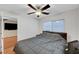 This bedroom has wood floors, a ceiling fan, and a view to the living room at 7873 Marbledoe St, Las Vegas, NV 89149