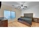 A cozy bedroom featuring a ceiling fan, wood laminate flooring, and neutral wall colors at 7873 Marbledoe St, Las Vegas, NV 89149