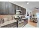A modern kitchen with stainless steel appliances, tile backsplash, and an adjacent dining area at 7873 Marbledoe St, Las Vegas, NV 89149