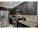 A spacious kitchen with stainless steel appliances, granite countertops, and dark cabinets at 7873 Marbledoe St, Las Vegas, NV 89149