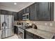 A spacious kitchen with stainless steel appliances, granite countertops, and dark cabinets at 7873 Marbledoe St, Las Vegas, NV 89149