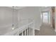 Hallway featuring carpeted stairs with white railing, light fixture, and doorways to rooms at 8186 Lone Boulder St, Las Vegas, NV 89113