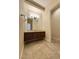 Traditional bathroom vanity area with tile floor, dark wood cabinets and an open doorway to toilet area at 861 Majestic Ridge Ct, Henderson, NV 89052