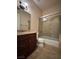 A well-lit bathroom with a dark wood vanity, tile floors, a glass-enclosed shower, and a toilet at 861 Majestic Ridge Ct, Henderson, NV 89052
