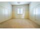 Spacious bedroom with neutral carpet, panelled walls, and window with light coming through shutters at 861 Majestic Ridge Ct, Henderson, NV 89052