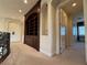 Hallway with built in bookcase, beige colored walls, carpet, white trim and doorway to another room at 861 Majestic Ridge Ct, Henderson, NV 89052