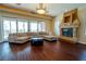 Bright living room featuring a stone fireplace, wood floors, and a large sectional sofa at 861 Majestic Ridge Ct, Henderson, NV 89052
