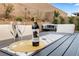 Elegant outdoor dining setup with wine glasses, a bottle of wine, and comfortable patio seating at 8705 Fordster St, Las Vegas, NV 89166