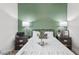 Cozy bedroom with decorative green accent wall, matching nightstands and lamps offering a relaxing retreat at 8705 Fordster St, Las Vegas, NV 89166