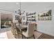 Bright dining area with wood table, modern chandelier, and backyard view at 8705 Fordster St, Las Vegas, NV 89166