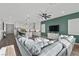 Spacious living area with a gray sectional sofa, television, and white kitchen with an island at 8705 Fordster St, Las Vegas, NV 89166
