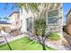 Private backyard featuring a patio area, artificial grass, and mature rose bushes at 9171 Denver Sky Ave, Las Vegas, NV 89149
