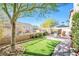 Relaxing backyard with artificial grass, a stone patio and comfortable seating at 9171 Denver Sky Ave, Las Vegas, NV 89149