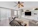 Spacious living room featuring a large TV, built-in shelving, and a sliding glass door for ample natural light at 9171 Denver Sky Ave, Las Vegas, NV 89149