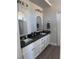 Modern bathroom featuring dual sinks, dark countertops, stylish mirrors, and ample lighting at 9328 Jumpin Juniper Ave, Las Vegas, NV 89129