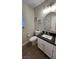 Updated half-bathroom featuring stylish vanity, modern fixtures, and hardwood floors at 9328 Jumpin Juniper Ave, Las Vegas, NV 89129