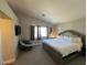 Spacious main bedroom featuring plush carpet, accent chair, and a comfortable king-size bed at 9328 Jumpin Juniper Ave, Las Vegas, NV 89129